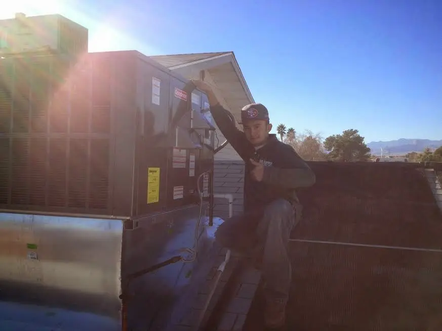 HVAC technician performing HVAC Inspection on a rooftop unit in Seekonk